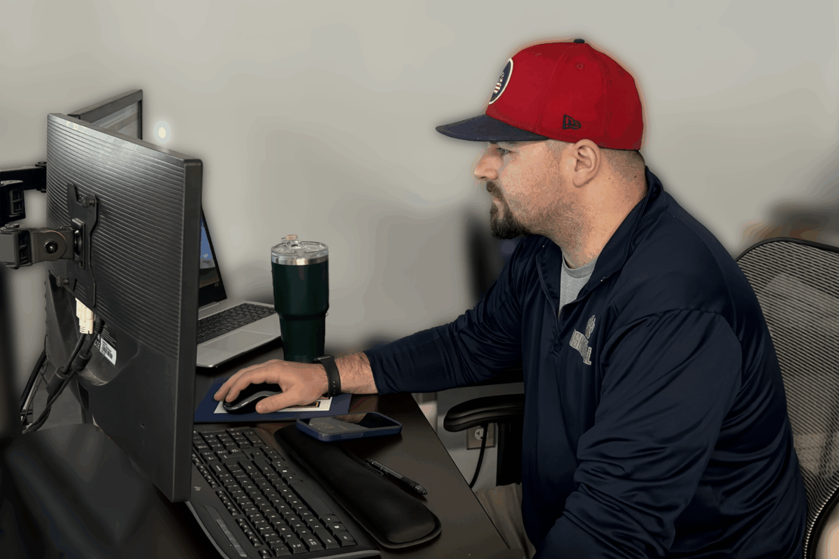 A Third Party Logistics broker planning a supply chain for a customer, working at his desk in front of a computer