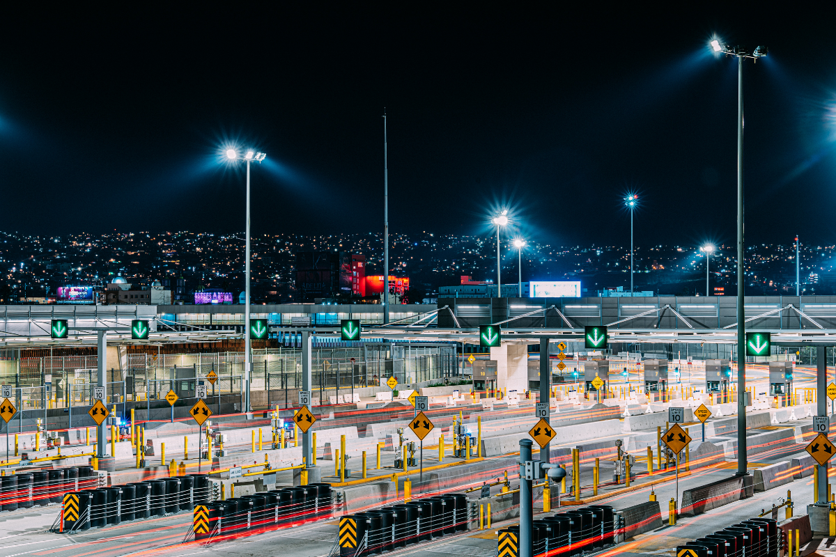 a busy U.S.–Mexico border crossing with inspection booths and freight traffic